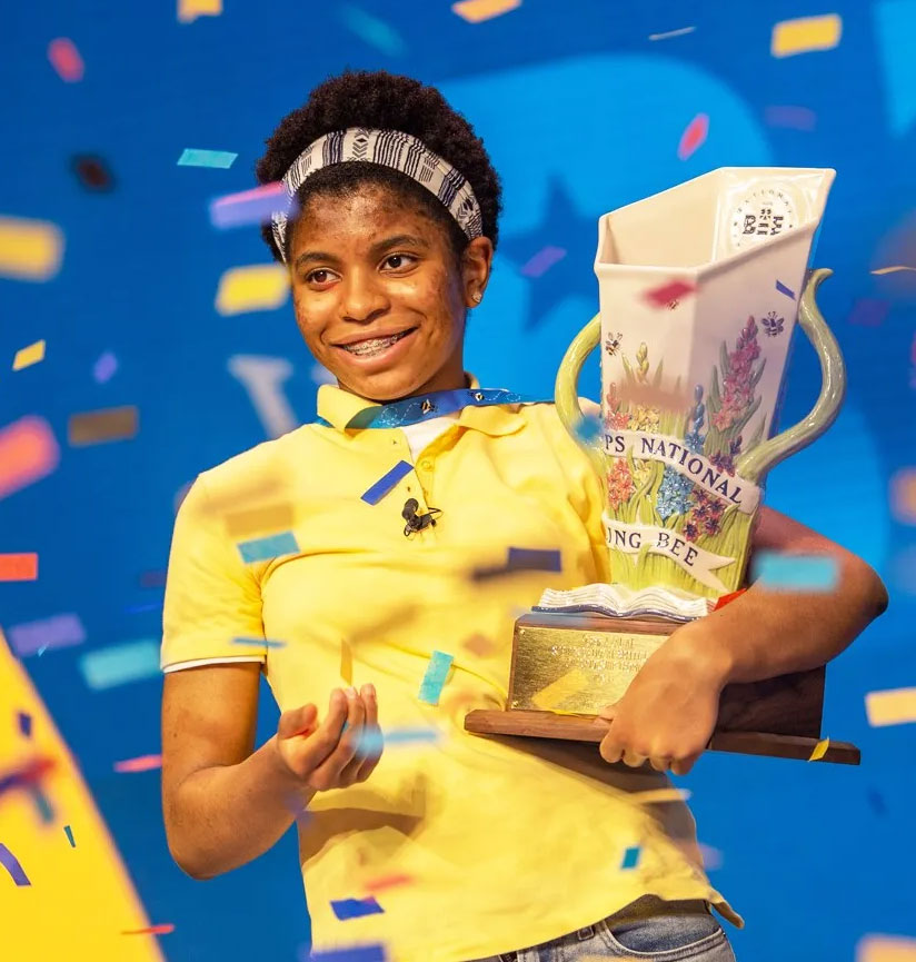 Zaila Avant-garde holding national spelling bee trophy with confetti coming down