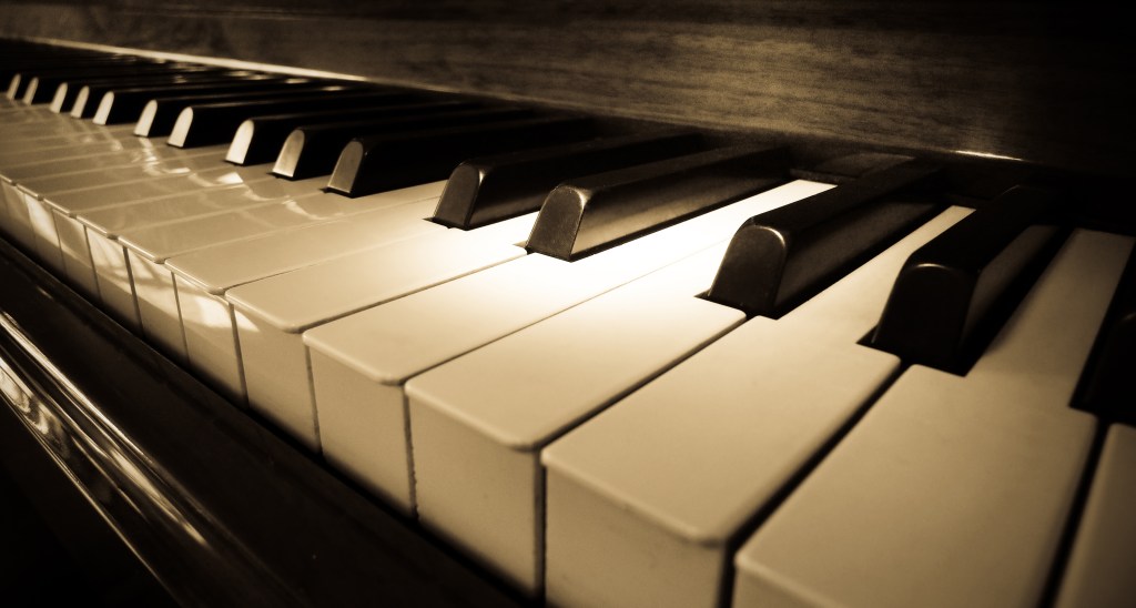 close-up of piano keys with dark shadowing